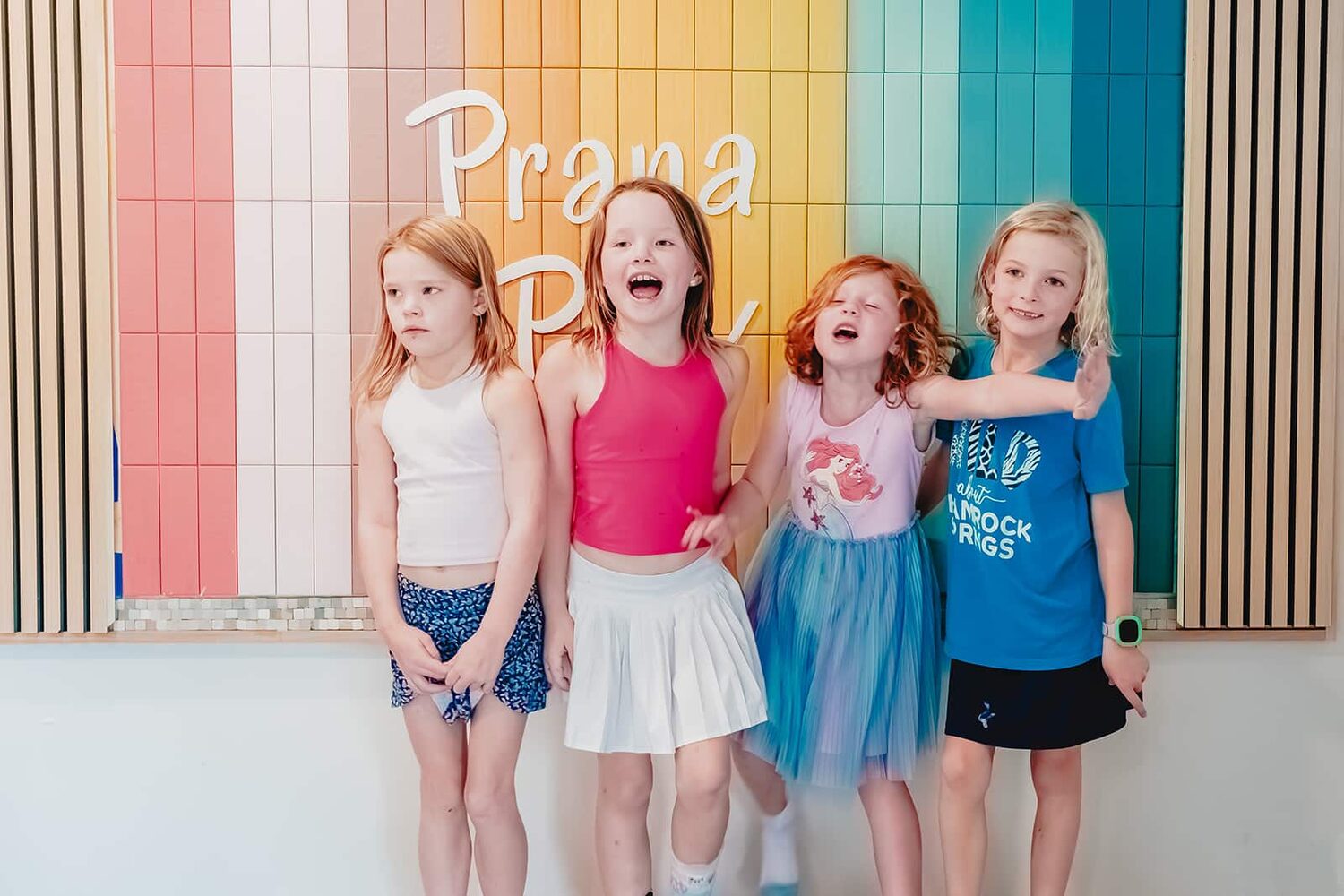 Children smiling together at the colorful Prana Play mural in Carmel