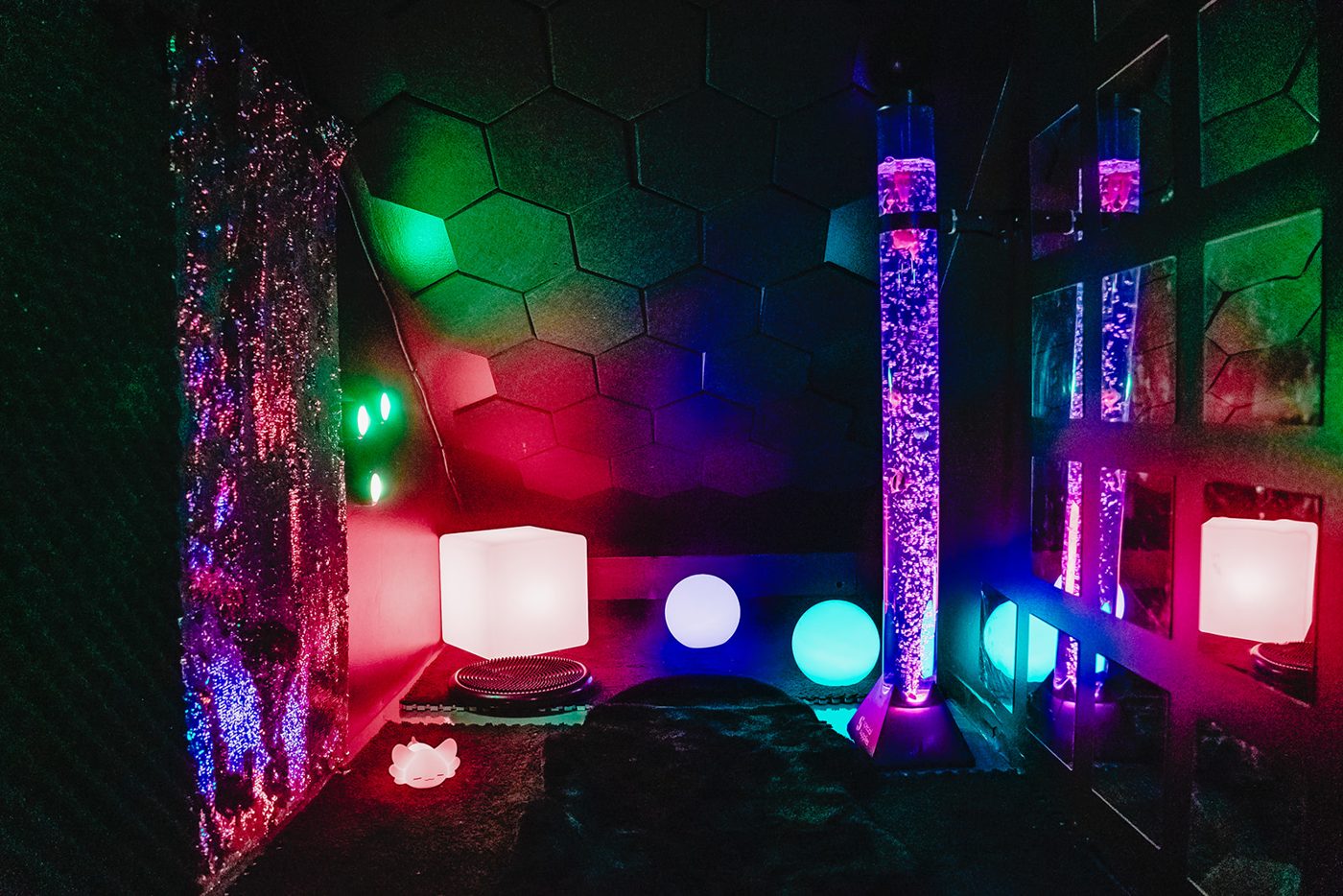 Calm sensory room with a rainbow arch and swing at Prana Play in Carmel, Indiana
